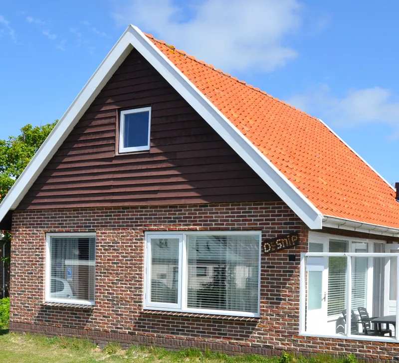 Het huis met zijn donkere houten gevel en één raampje.